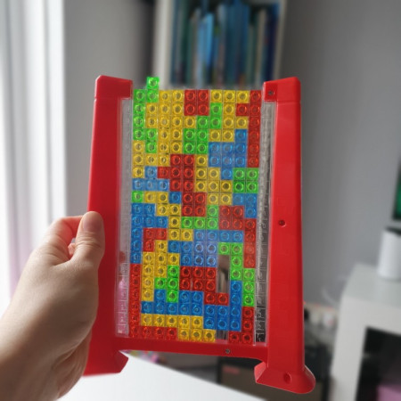 Joc de inteligenta Tetris puzzle tangram Flippy, 70 de piese multicolore, 3D, montessori, interactiv, din plastic, zar inclus, sac depozitare piese, varsta peste 6 ani, 23 x 19.8 x 5 cm, cadru rosu